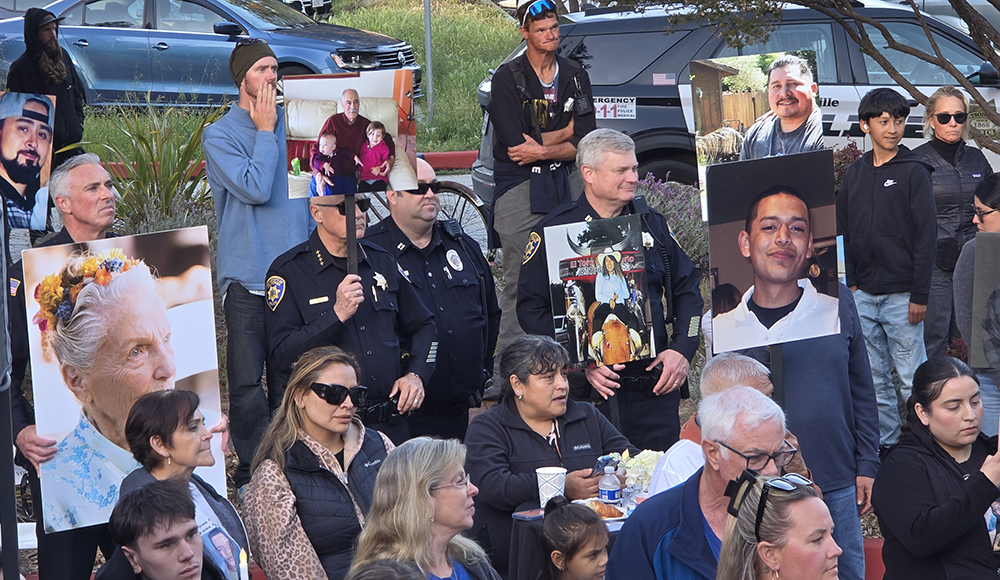 People holding photos of crime victims at Santa Cruz vigil