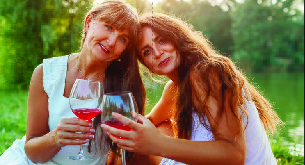 two women toasting wine outdoors mothers day celebration lifestyle