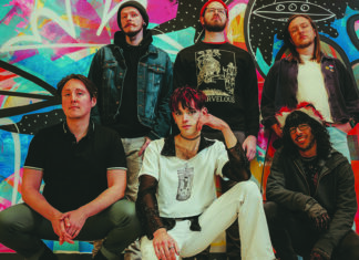 Things to do in Santa Cruz Runaway Ricochet band poses in front of colorful mural