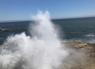 Don’t Turn Your Back on the Ocean Large wave crashing violently against rocks at West Cliff Santa Cruz