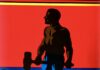 The Editor’s Desk Illustration of John Henry holding a hammer against a red and blue background.