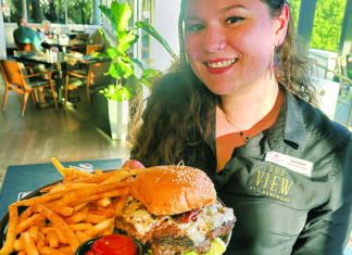 Hyper-Local Server Veronica Hodes holds The Bee Smash Burger with fries at The View at Chaminade.