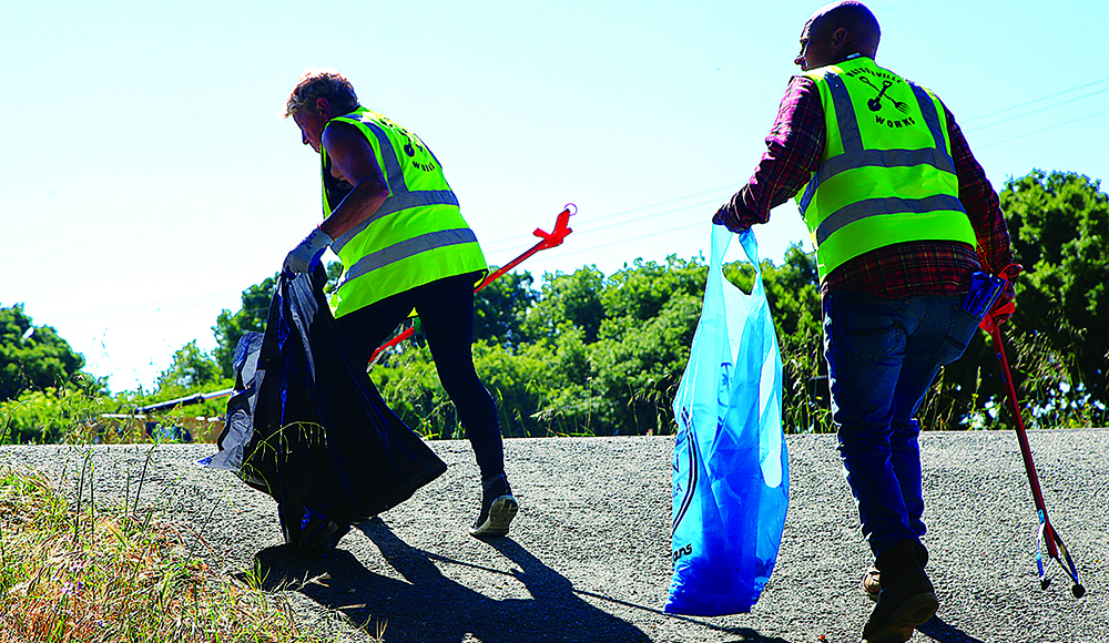 Volunteers collect trash along the Pajaro River levee during Santa Cruz County Cleanup Day.