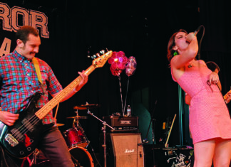 The Editor’s Desk Kat Moss sings onstage with a band during a live performance.