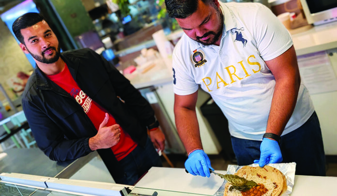 Downtown Lowdown India Gourmet staff prepare an Indian wrap at Abbott Square Market in Santa Cruz.