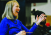 Tragedy Into Art Choral director Cheryl Anderson smiles and gestures during a rehearsal.