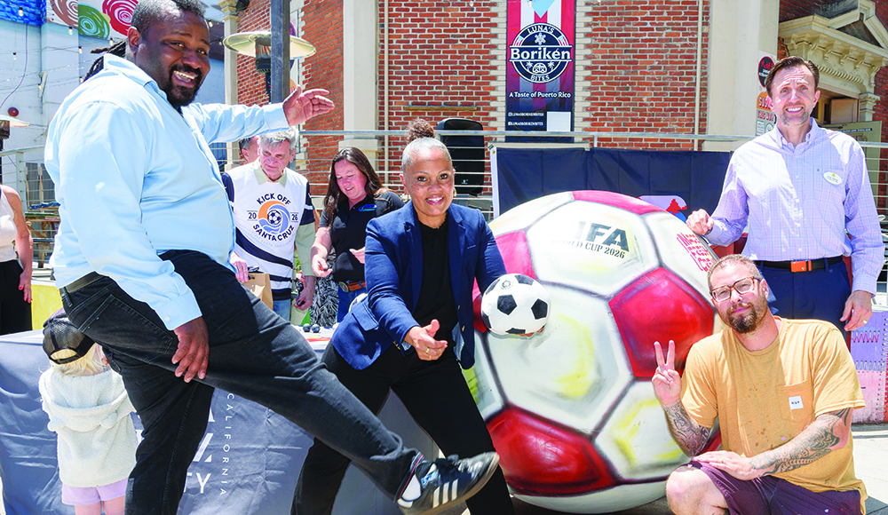 Santa Cruz community leaders and organizers pose with a giant World Cup soccer ball outside a downtown restaurant.