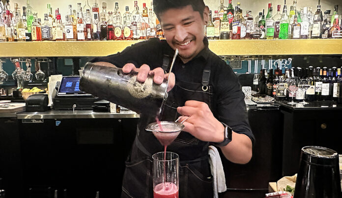 Main Place Bartender Rafael Reyes pours a pink vodka cocktail at Mane Kitchen & Cocktails in downtown Santa Cruz.