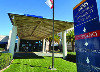 Big Relief Watsonville Community Hospital entrance sign showing directions to emergency and main entrance.