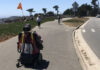DANGER AFOOT A person using a mobility scooter travels along the West Cliff Drive path in Santa Cruz, separated from car traffic.