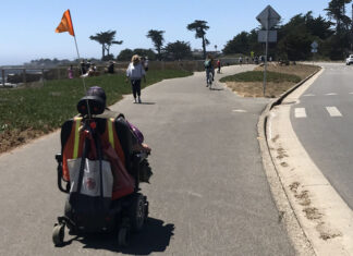 DANGER AFOOT A person using a mobility scooter travels along the West Cliff Drive path in Santa Cruz, separated from car traffic.