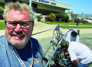 We Have Liftoff Tim Wood takes a selfie outside Woody’s at Watsonville Airport as a collectible motorcycle is moved inside.