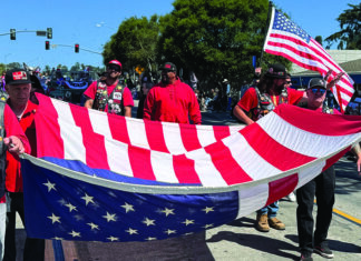 July Fourth Parades People carry a large American flag during a Fourth of July parade in Santa Cruz County.