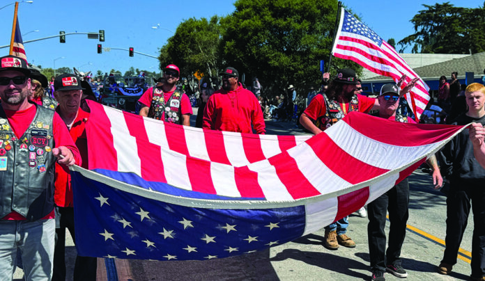 July Fourth Parades People carry a large American flag during a Fourth of July parade in Santa Cruz County.