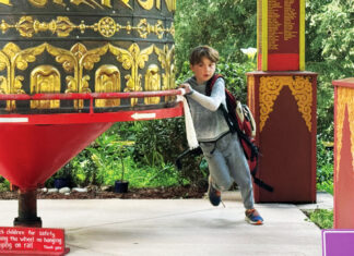Rejoice, Rejoice A child spins a large prayer wheel at Land of Medicine Buddha in Soquel.