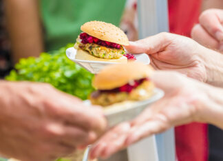 Green Beings: VegFest ’26 Hands hold small vegan sliders at Santa Cruz VegFest.