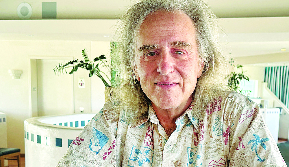 Santa Cruz writer Wallace Baine poses indoors in a patterned shirt.