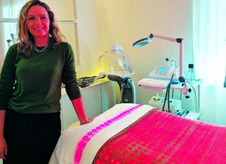 Summer Glow Milene Freire stands beside a skincare treatment bed at Glow Prescription Skincare in Capitola.