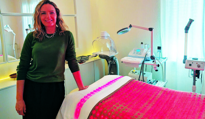 Summer Glow Milene Freire stands beside a skincare treatment bed at Glow Prescription Skincare in Capitola.