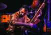 World Music Kinship Keshav Batish performs on sitar with drums and other instruments behind him
