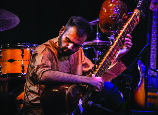 World Music Kinship Keshav Batish performs on sitar with drums and other instruments behind him
