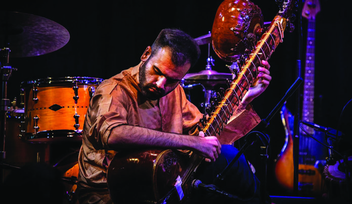 World Music Kinship Keshav Batish performs on sitar with drums and other instruments behind him