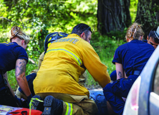 The Editor’s Desk Firefighters and emergency medical responders assist a person beside a vehicle