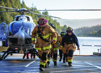 Fighting Fire Zayante volunteer firefighters walk away from a medical helicopter at Loch Lomond