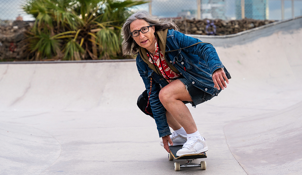 Older woman skateboarding at a skatepark