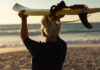 The Editor’s Desk Older surfer carrying a surfboard at the beach