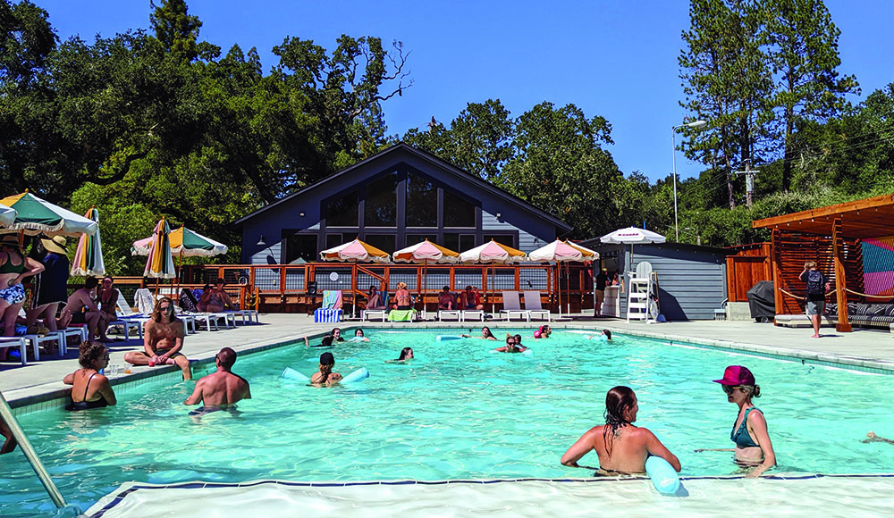 Guests swim and relax beside the pool at Trout Farm Inn in Felton
