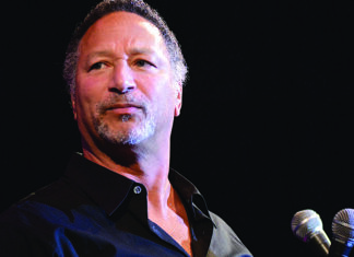 The Price of Prevention Santa Cruz dentist stands onstage beside two microphones