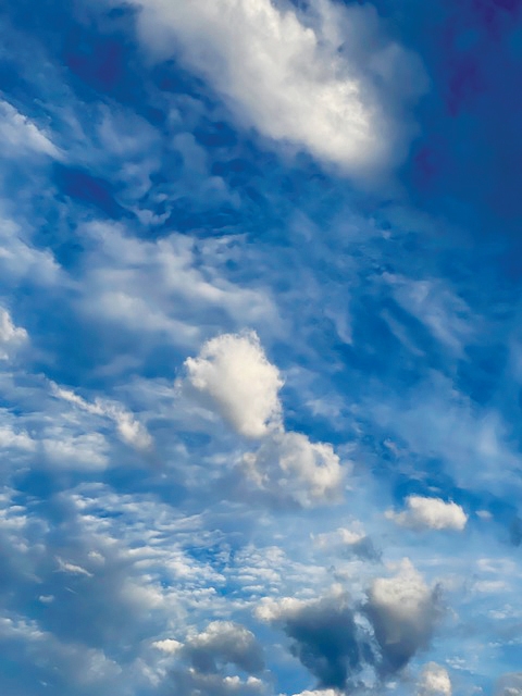 Billowing white clouds against a vivid blue sky