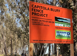 Fenced Out Orange Capitola Bluff Fence Project construction sign beside the coastal trail.