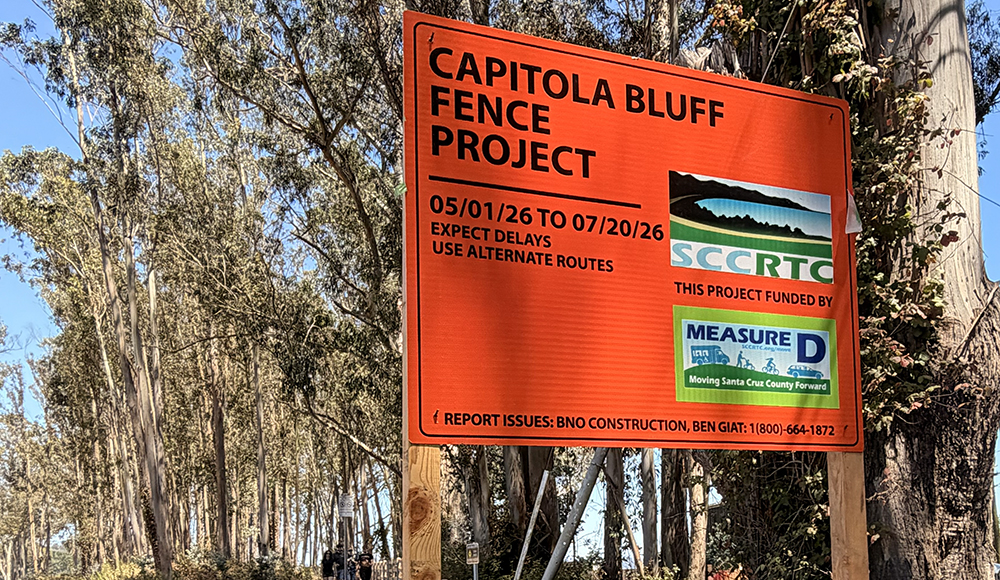Orange Capitola Bluff Fence Project construction sign beside the coastal trail.