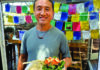 Peak Dumplings River Café owner Rabgee Kunchok holding beef momo dumplings and salad