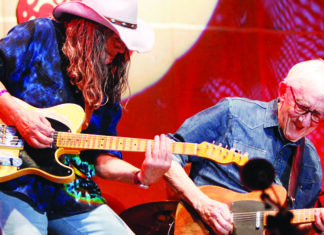 High Speed Bill Kirchen and Nina Gerber perform on electric guitars onstage.