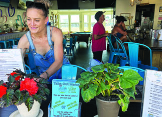 Slay Bar Bay Bar & Grill co-owner Brittny Beshore arranges plants and signs inside the Capitola Village bar and restaurant.