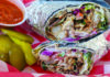 Wrap Star A Turkish döner wrap filled with meat, fries, lettuce, tomato, red cabbage and sauce, served with pickles and red sauce.
