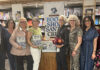 Season of Ice Eight people pose at Bookshop Santa Cruz, several holding copies of Winter in America (Still.