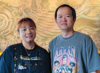 New Fire, Old Fears Nancy and Arun Sadkiriyasab stand together inside Lemongrass restaurant in Moss Landing, with gold artwork behind them.