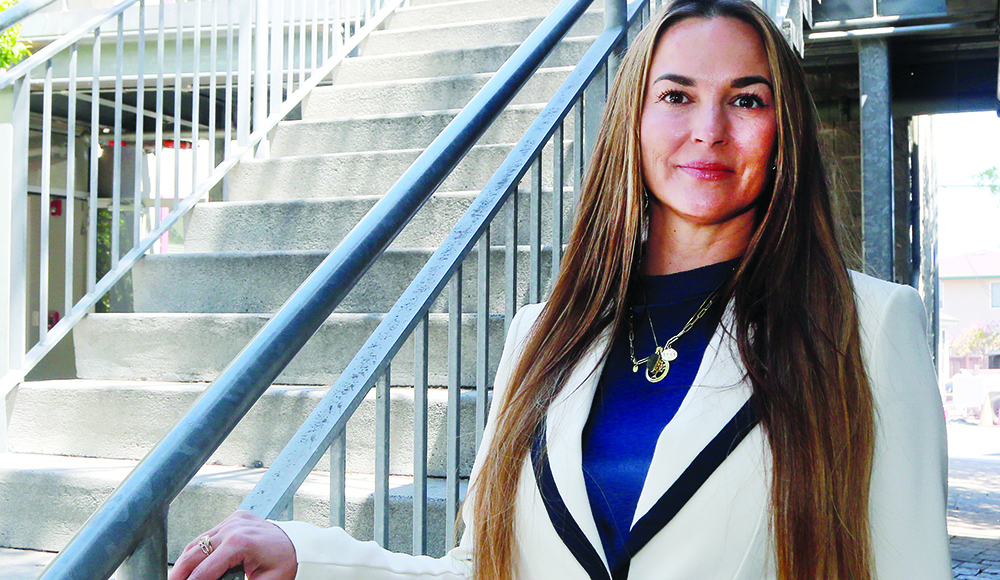 Janus CEO Amber Williams stands beside an outdoor staircase in Santa Cruz County.