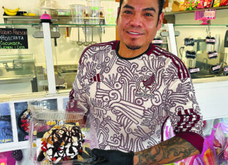 Nice Dreams Hugo Moreles holds an ice cream dessert drizzled with chocolate sauce at Los Freseros Paleteria’s counter in Ben Lomond.