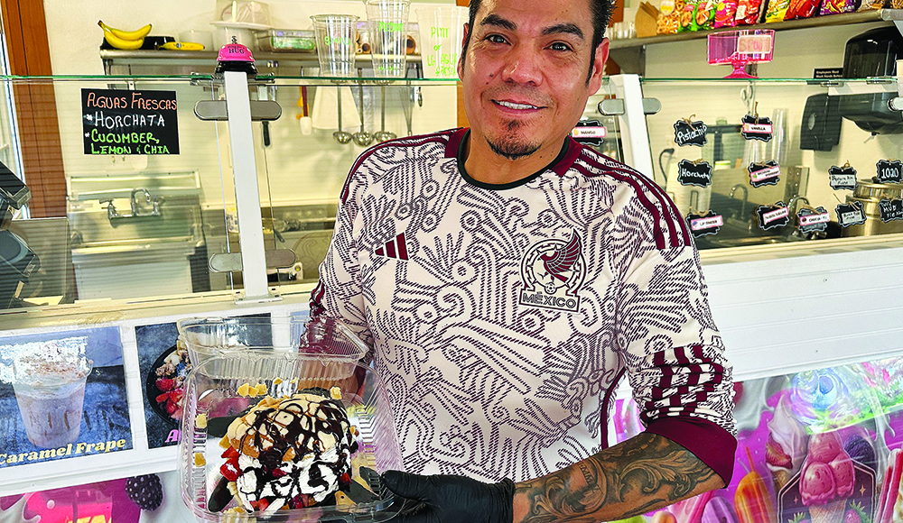 Hugo Moreles holds an ice cream dessert drizzled with chocolate sauce at Los Freseros Paleteria’s counter in Ben Lomond.