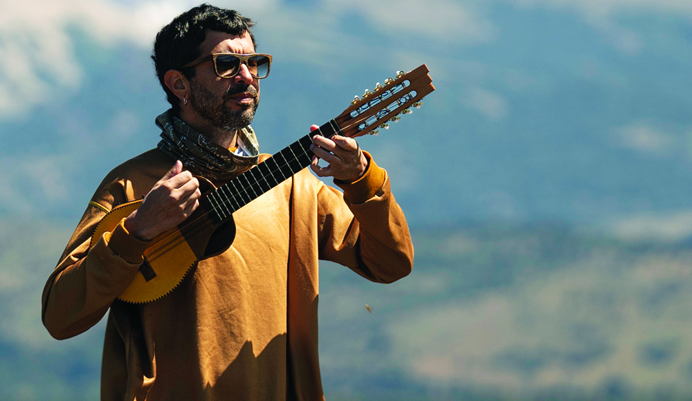 Facundo Salgado of Rumbo Tumba performing outdoors with a stringed instrument.