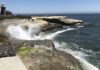 Coastal Protection Waves crash against the Santa Cruz coastline near a lighthouse