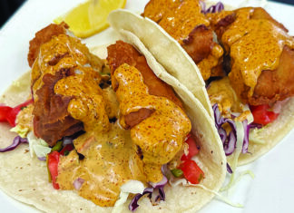 Fareway Food Battered fish tacos topped with shredded cabbage, diced vegetables and creamy orange sauce at The Clubhouse.