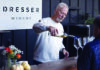 Berry Special A man pours white wine into a tasting glass for a guest at a counter beneath a Dresser Winery sign.