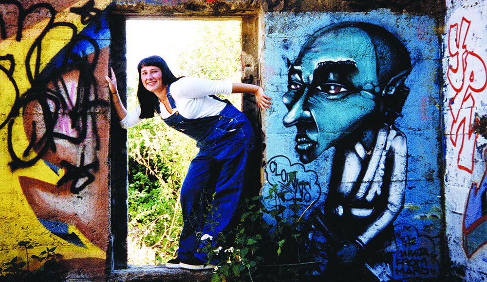 Aubrey Graves leans through a doorway surrounded by colorful graffiti at the White Lady’s House in 1999.