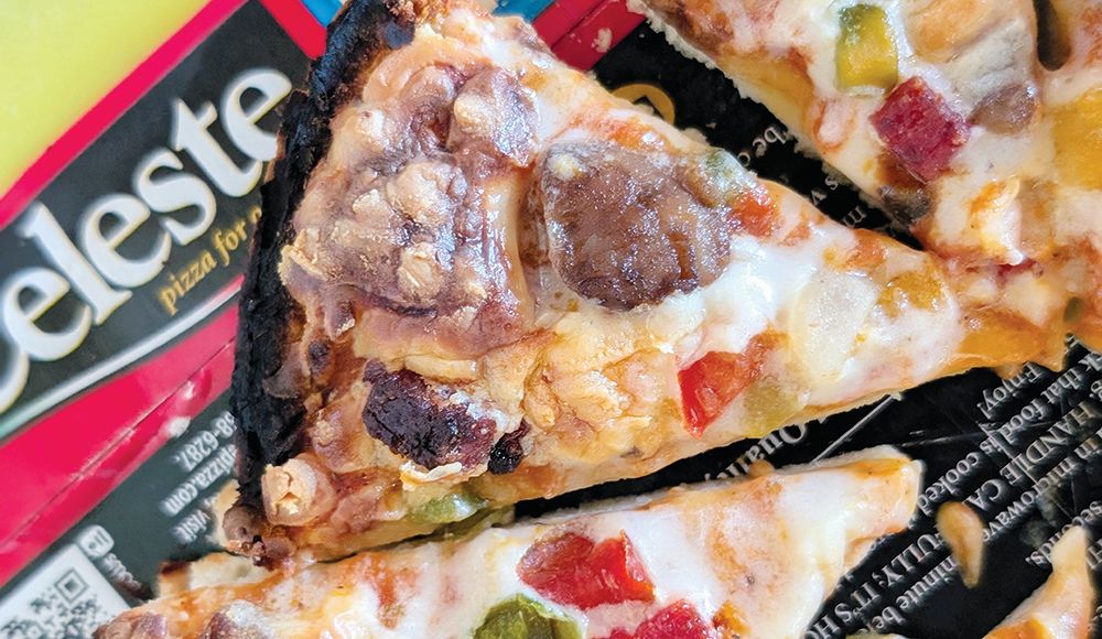 Alt text: Close-up of baked Mama Celeste pizza slices with sausage and diced peppers resting on Celeste packaging.